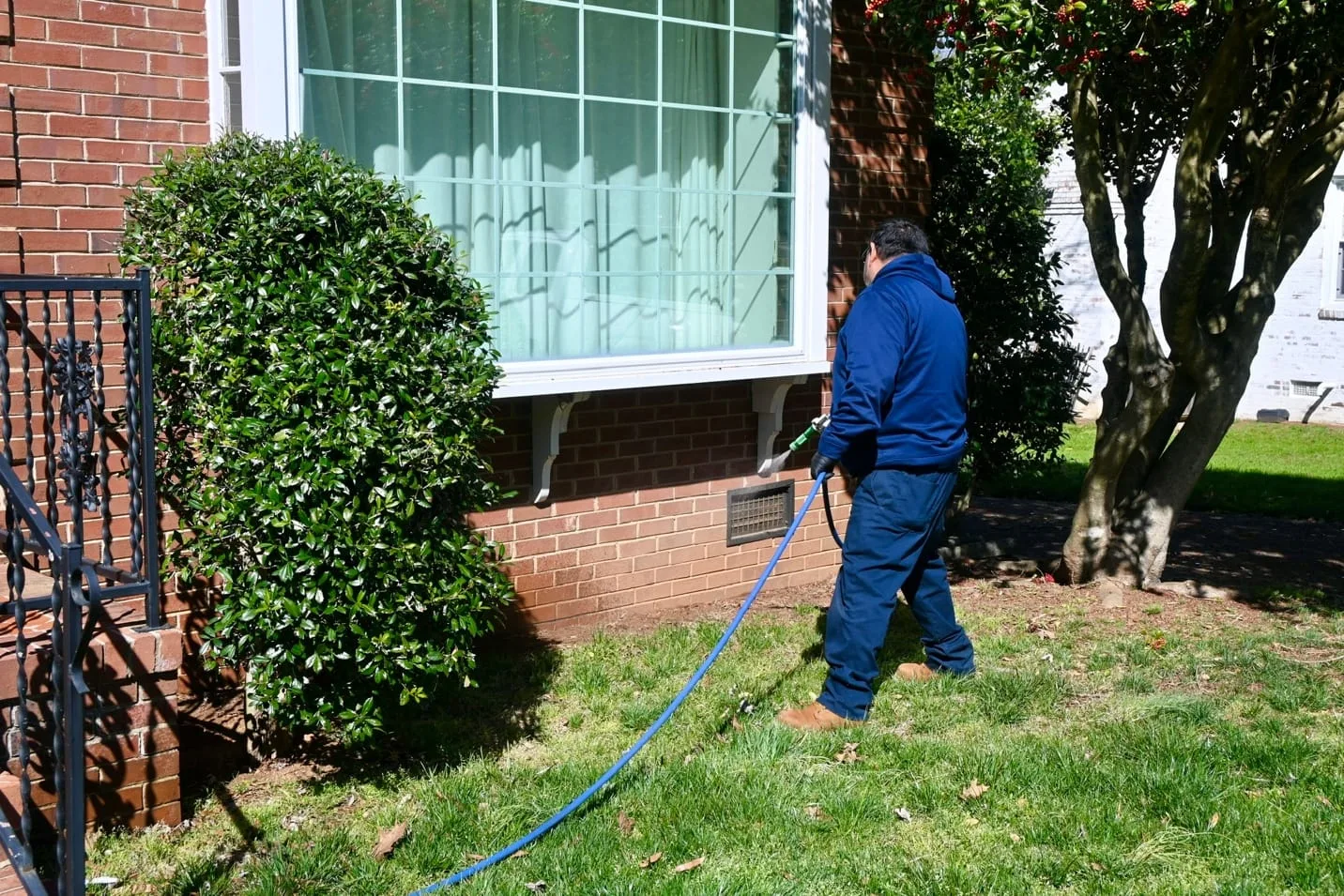 Pest control technician spraying pesticide around a home during spring. (Piper Allen, Clegg’s Pest Control Marketing Manager)