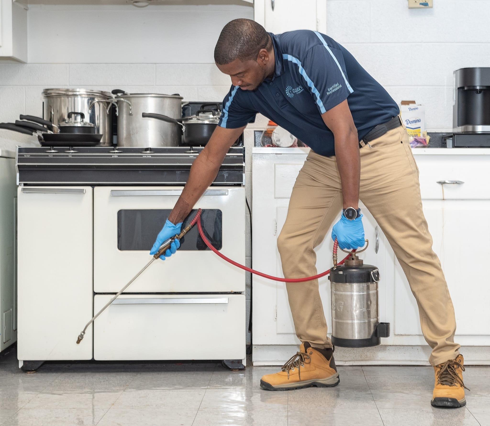 Clegg's technician performing a termite treatment inside a Durham, NC home