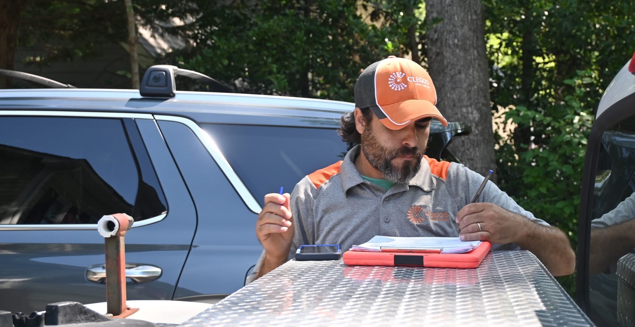 Clegg's technician documenting a termite inspection outside a Durham, NC home